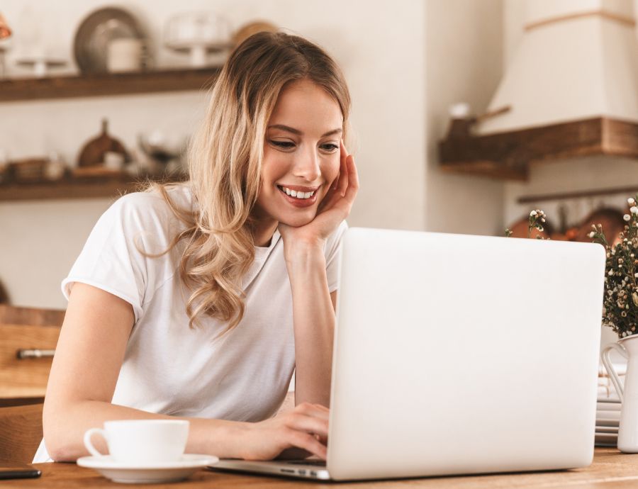 Woman Smiling While Using Laptop